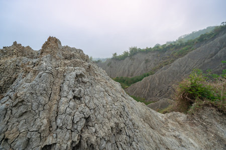 Wide view of the eroded white mudstone badlands of Caoshan Moon World in Tainan, Taiwan. The stark,...