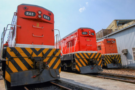 Three orange diesel locomotives, including R42, R55, and R34, are parked on tracks at the historic...