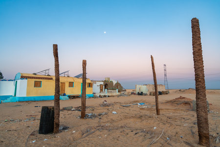This image captures abandoned homes in the desert near Aswan, Egypt, at dawn. The serene sky and desolate landscape create a striking contrast, highlighting the beauty and isolation of the area.の写真素材