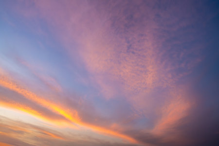 A breathtaking sunset sky over the Nile River near Esna Lock, Egypt, ablaze with vibrant pink, purple, and orange hues. The expansive sky creates a stunning backdrop for the tranquil waters at dusk.の写真素材