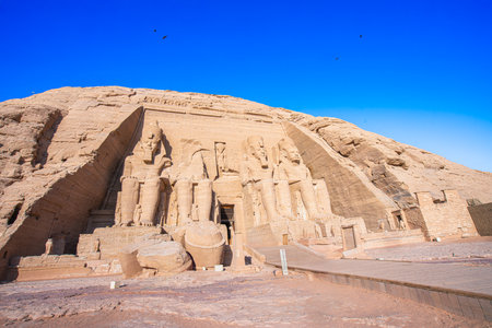 The site features four 20-meter statues of Ramses II carved into rock. Murals inside depict the Pharaoh's victories, highlighting ancient Egypt's grandeur. Abu Simbel Temples, Aswan, Egypt.の写真素材