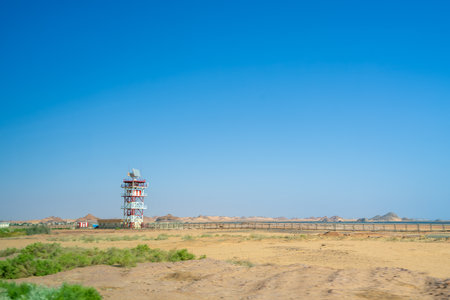 A distant communication tower stands in the expansive desert landscape near Aswan, Egypt, showcasing the remote border region between Abu Simbel Temples and Edfu.の写真素材