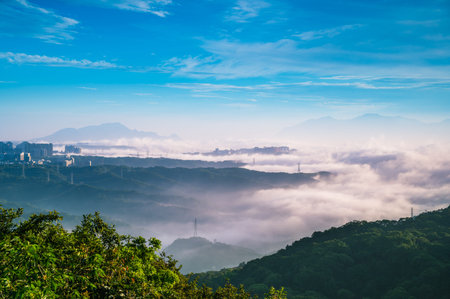 Tranquil morning scene in Shilin New Taipei Taiwan, with misty mountains, power lines, and faint...
