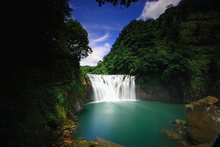 Stunning Shifen Waterfall in Pingxi District, New Taipei City, surrounded by lush greenery, captured...