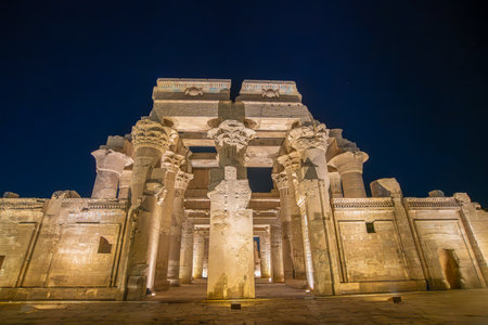 Majestic night view of Temple of Kom Ombo in Egypt showcasing ornate columns with elaborate capitals under dramatic lighting.の写真素材