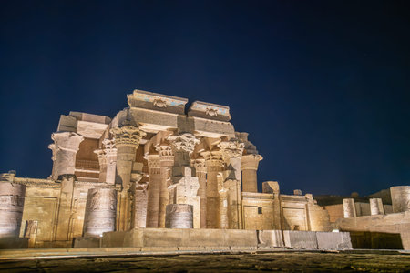 The magnificent Temple of Kom Ombo is illuminated at night against a dark sky, highlighting its...