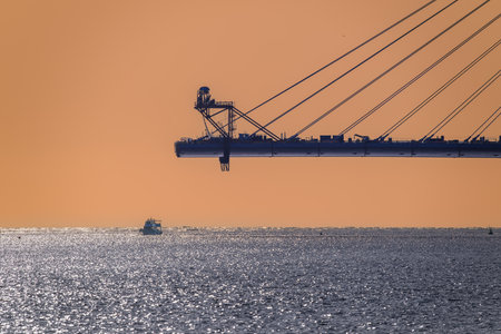 Stunning view of the pink bridge spanning the Danshui River in Taiwan at twilight, with calm waters and distant mountains. Shot on April 29, 2025.の写真素材