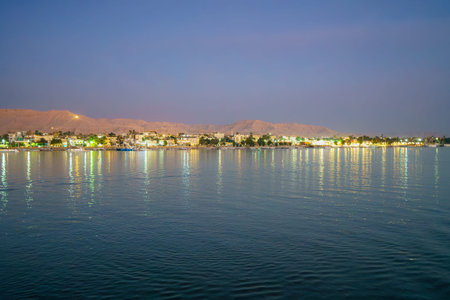 Scenic springtime night view of Luxor West Bank illuminated along the Nile River in Egypt at dawn...