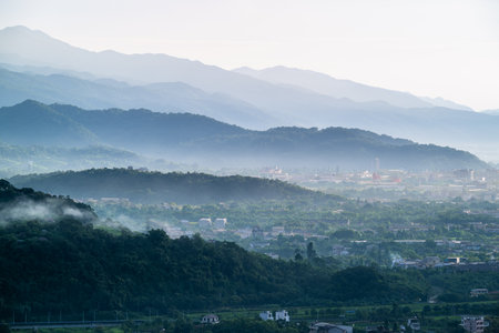 Epic summer dawn with dramatic cloudscape over a cityscape. Light reflects on the ocean waves.の写真素材