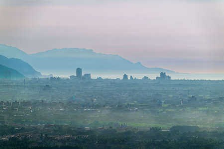 Atmospheric blue hour or dawn time lapse shot of Yilan Plain city skyline from Yuanshan Township Taiwan Mountains and buildings emerge through thick summer haze.の写真素材