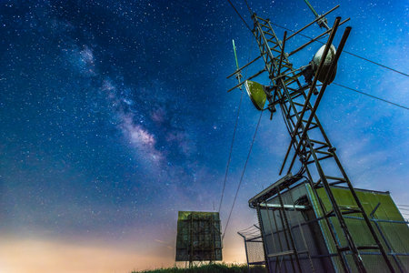 Stunning Milky Way galaxy above abandoned weather radar tower at Wufenshan in Shuangxi, New Taipei City, Taiwan. Starry night sky with city lights below.の写真素材
