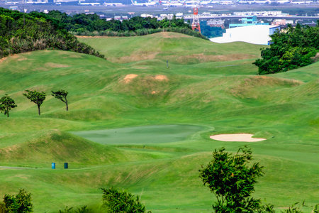 Panoramic view of the lush green fairways at Golf Course in Lukou, Taoyuan City, surrounded by rolling hills and dense forest, ideal for outdoor leisure.の写真素材
