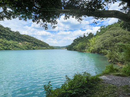 Crystal clear turquoise river flowing through lush green mountain valley in Wulai New Taipei City Taiwan on a sunny morningの写真素材