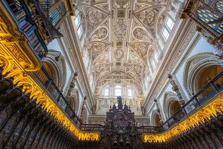 Cordoba, Spain - March 13, 2025: Wide view of the carved mahogany choir stalls, historic organs and the vaulted white ceiling inside the Cathedral.の写真素材