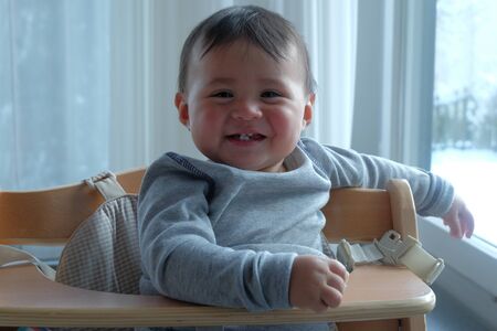close up little cute boy smiling on the baby's chairの写真素材