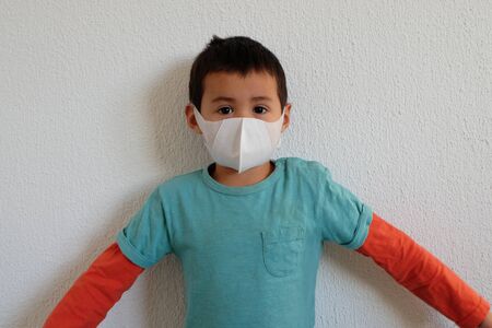 Young mixed race Thai-Swiss child boy wearing a mask isolated on white background. Virus protects concept idea. Coronavirus protection.の写真素材