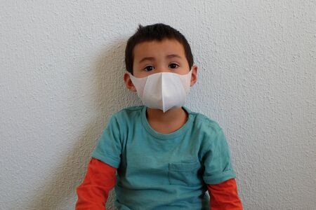 Young mixed race Thai-Swiss child boy wearing a mask isolated on white background. Virus protects concept idea. Coronavirus protection.の写真素材