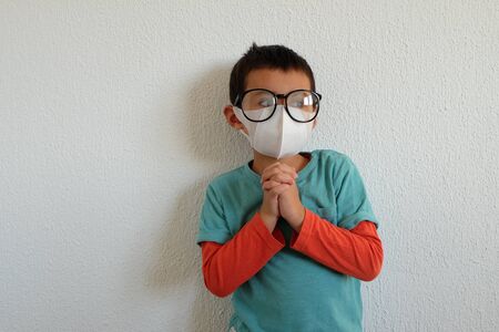 Young mixed race Thai-Swiss child boy wearing a mask and glasses isolated on white background. Virus protects concept idea. Coronavirus protection.の写真素材