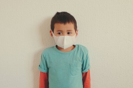 Young mixed race Thai-Swiss child boy wearing a mask isolated on white background. Virus protects concept idea. Coronavirus protection.の写真素材