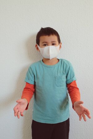 Young mixed race Thai-Swiss child boy wearing a mask isolated on white background. Virus protects concept idea. Coronavirus protection.の写真素材
