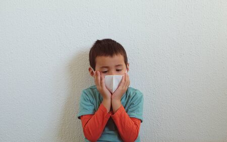 Young mixed race Thai-Swiss child boy wearing a mask isolated on white background. Virus protects concept idea. Coronavirus protection.の写真素材
