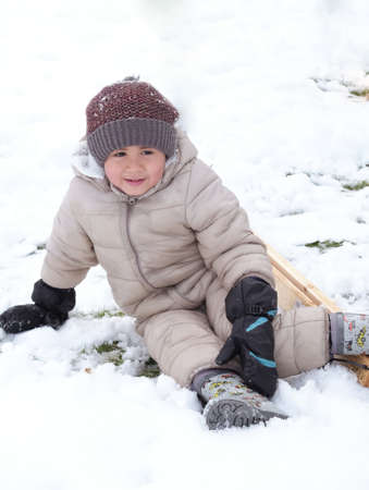A happy face of cute kindergarten kid boy playing white snow close up.の写真素材