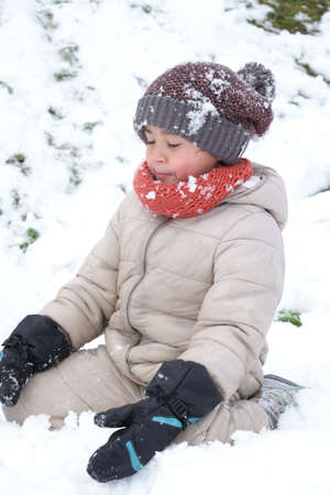 Portrait of happy cute kindergarten kid boy playing snow outdoor closeup.の写真素材