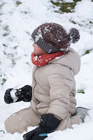 Portrait of happy cute kindergarten kid boy playing snow outdoor closeup.の写真素材