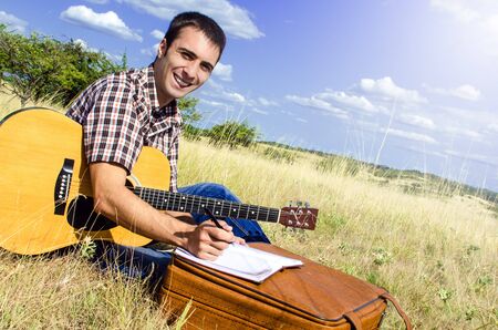 Cheerful traveling musician writes a song on sunny dayの写真素材
