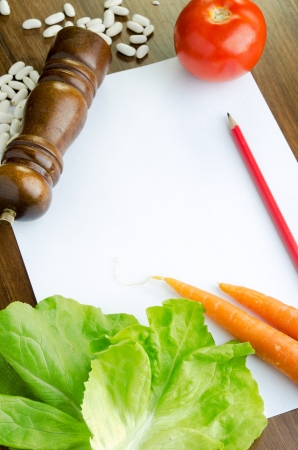 Cooking recipe and fresh colorful vegetables on kitchen tableの写真素材