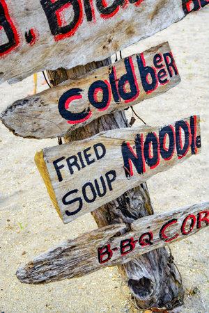 A tourist directional sign at the beach showing directions for food and drinks.の写真素材