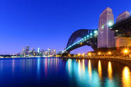 A view of Sydney Harbour Bridge looking towards the city at sunrise.