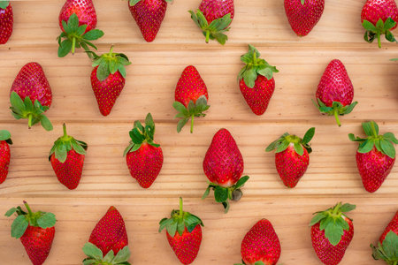 Arrangement of ripe strawberries on wood tabletop.の写真素材