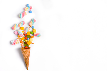 Ice cream cone flat lay image with colorful candy packing into the cone.の写真素材