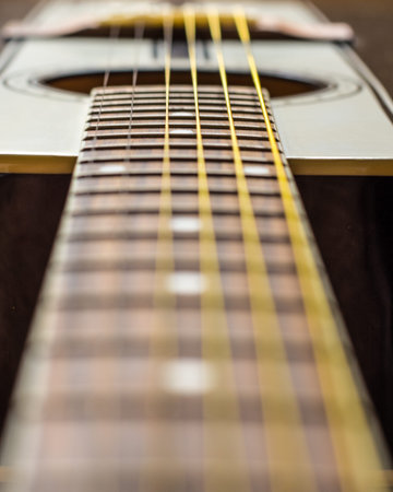 Guitar fret-board with a shallow focus.  Overall image has an aged look.