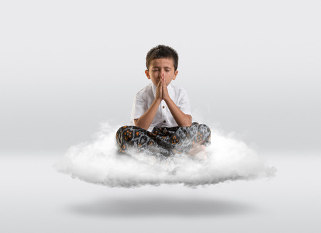 Young boy levitiating on a cloud with copy space all around.の写真素材
