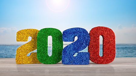 2020 new years 3D numbers on a table with ocean and horizon in the background.