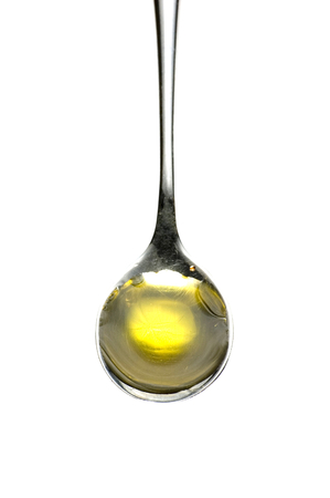 Teaspoon of olive oil isolated on whiteの写真素材