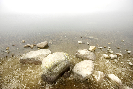 Mountain lake covered in mistの写真素材