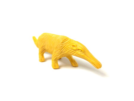 Close up of yellow plastic anteater toy isolated on white background.の写真素材