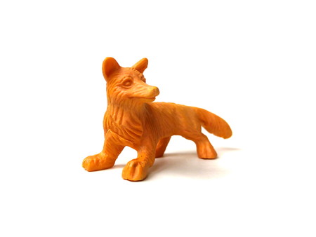 Close up of orange plastic fox toy isolated on white background.の写真素材