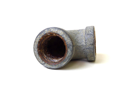 Close up of old galvanized steel pipe fitting isolated on white background.