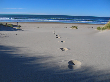 footprints in the sand heading towards to seaの写真素材