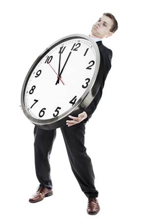 Businessman carrying heavy clockの写真素材