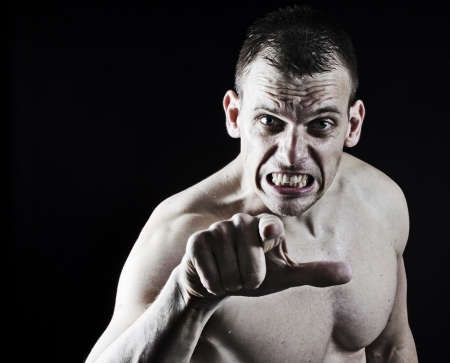 Very angry muscular man pointing to the camera