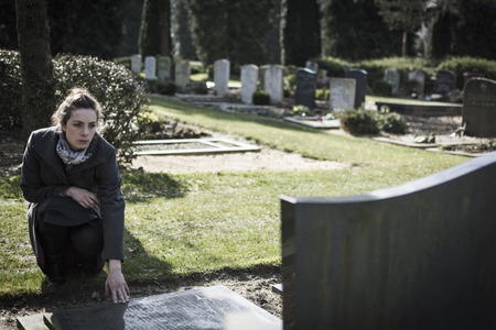 widow at gravestoneの写真素材