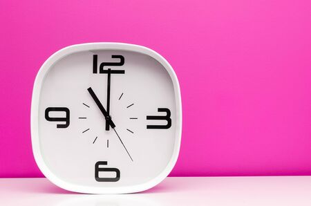 White clock on pink backgroundの写真素材