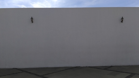 large white wall with 2 garden lightsの写真素材