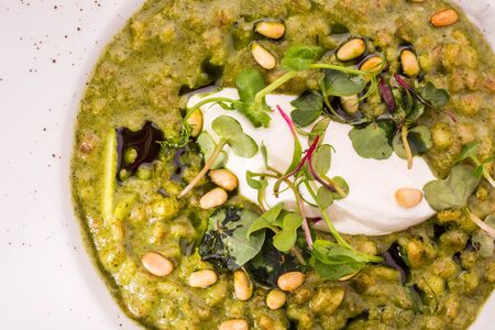 Orzotto with goat cheese and spinach with greens and pine nuts. Top viewの写真素材