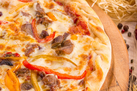 Pizza with mutton pieces, paprika and grated cheeseの写真素材